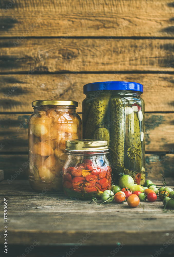 秋季时令泡菜和水果装在玻璃罐里，背景是质朴的木制谷仓。秋季前