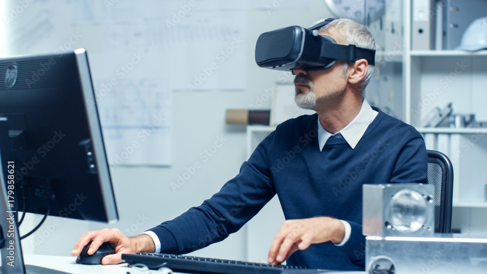 虚拟现实工程师戴着VR眼镜工作，同时在他的Pers上编程