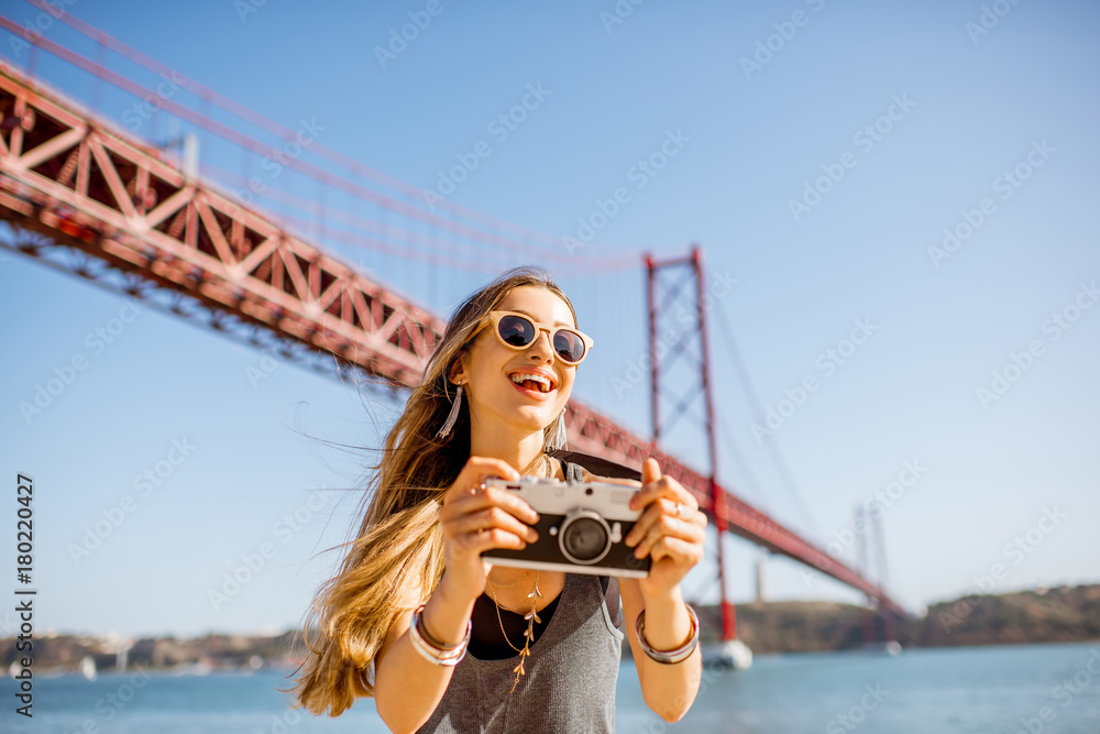 一位年轻女游客的肖像，带着相机站在著名的铁桥trav前