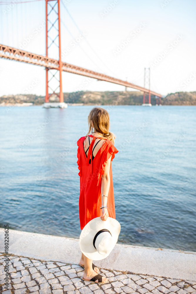 站在河边著名铁桥上欣赏风景的红衣女子