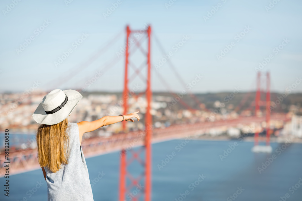 年轻的女游客在里斯本著名的铁桥上欣赏美丽的空中景观
