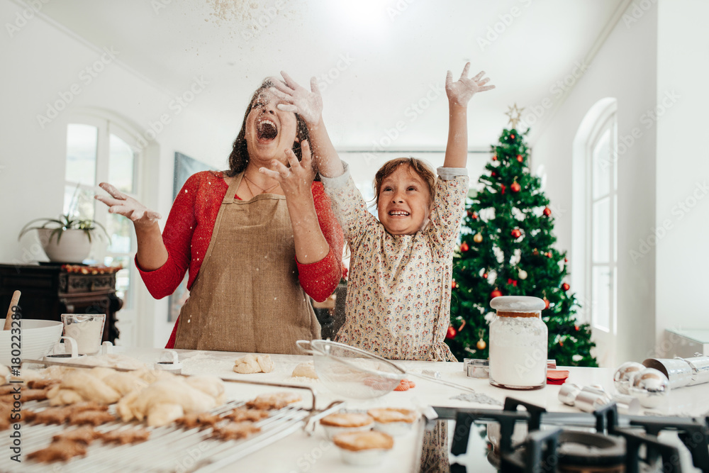 母亲和女儿在做圣诞饼干时玩得很开心。