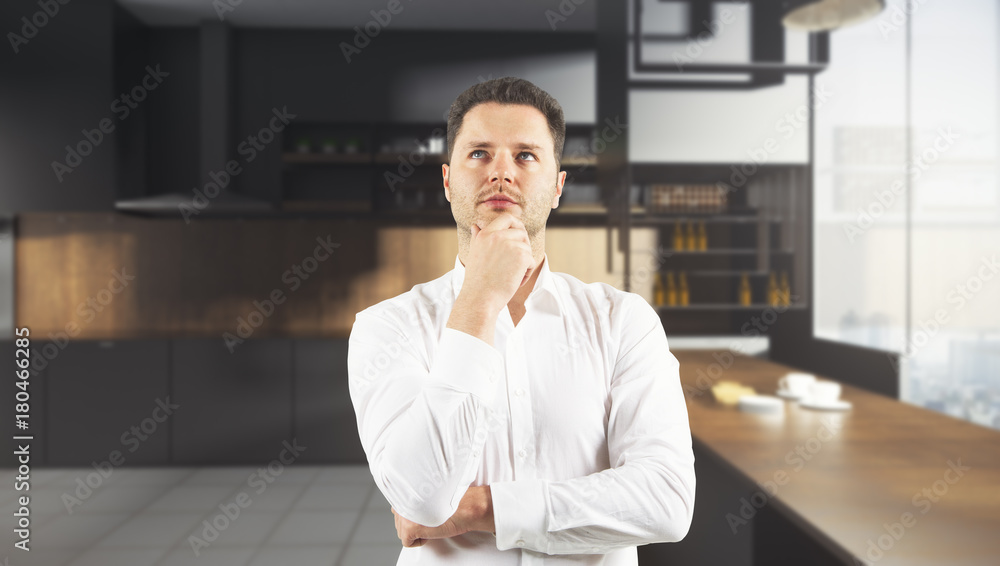 Thoughtful man in blurry kitchen