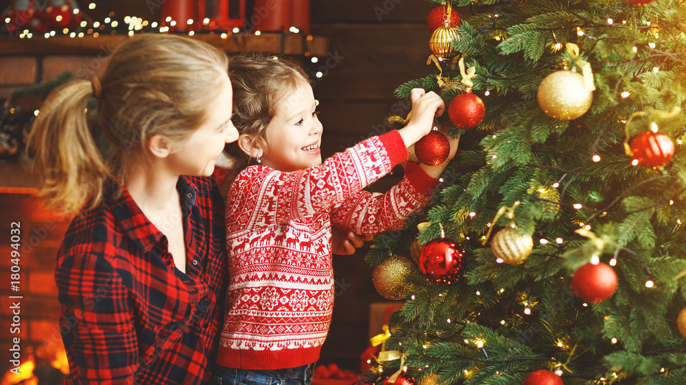 幸福的家庭母亲和小女孩装饰的圣诞树