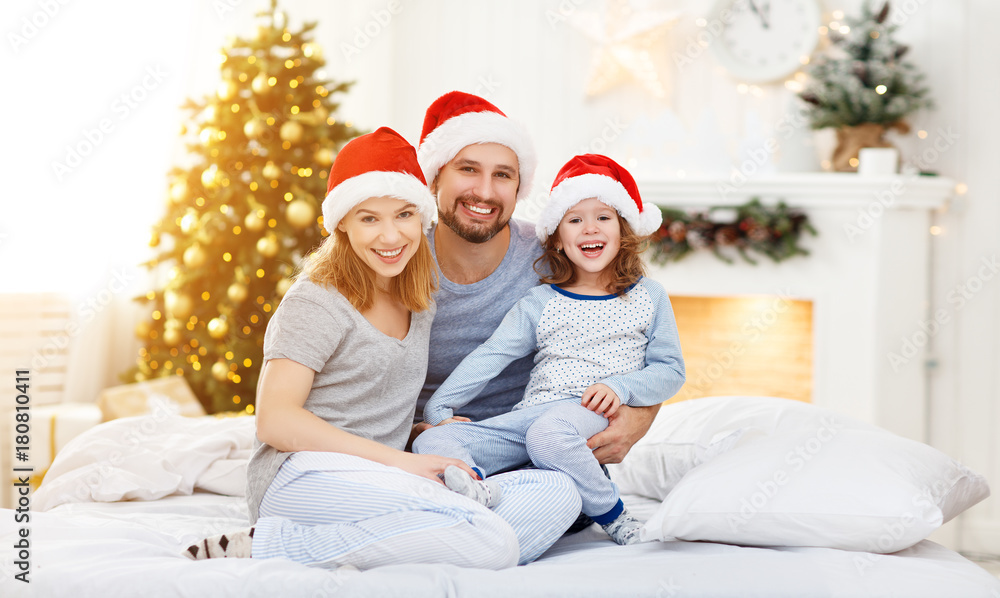 幸福的家庭母亲父亲和孩子在圣诞节早上躺在床上