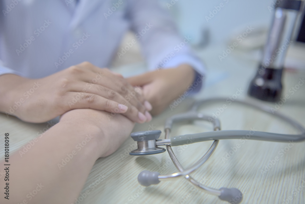 柔和的焦点医生握着病人的手寻求安慰。并确保治疗计划。