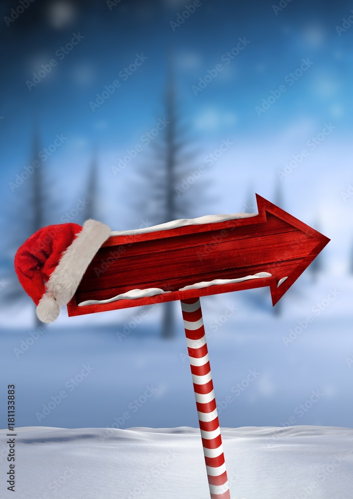 带圣诞老人帽的圣诞冬季景观中的木制路标