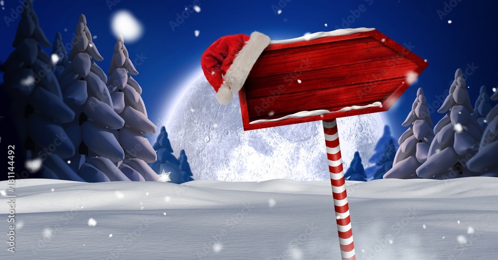 圣诞冬季景观和圣诞老人帽中的木制路标