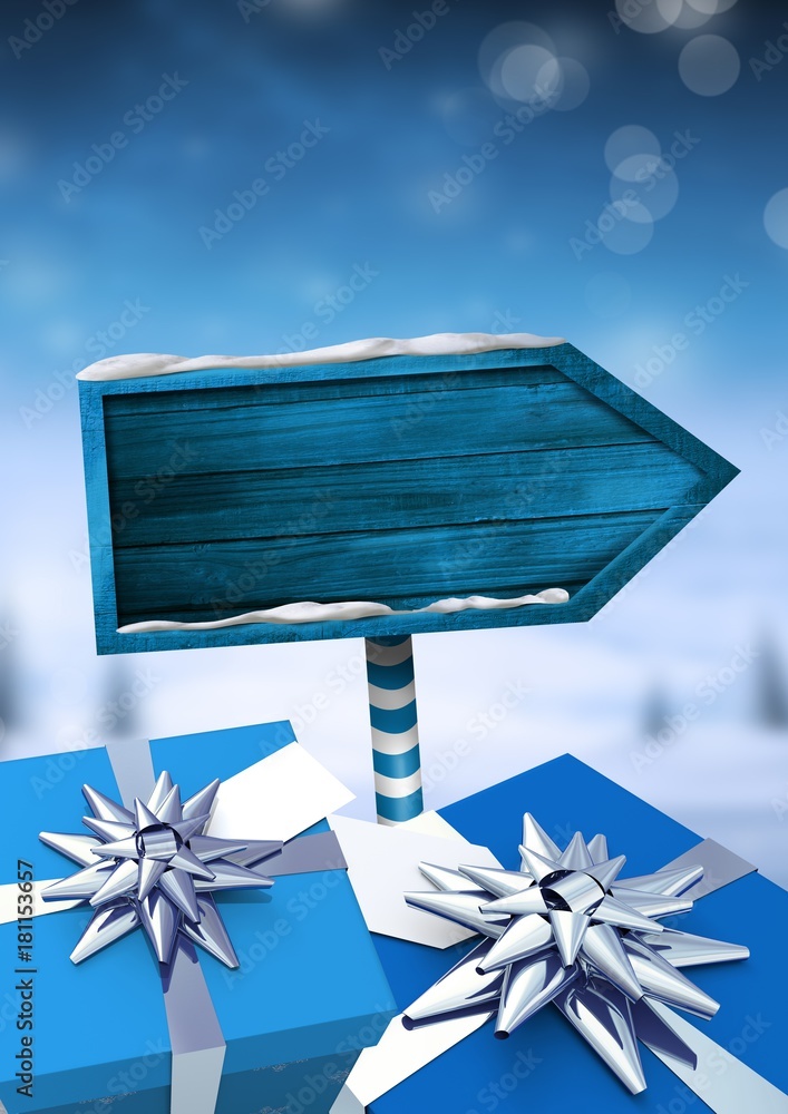 圣诞冬季景观中的礼物和木制路标