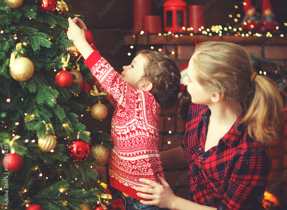 幸福的家庭母亲和小女孩装饰的圣诞树