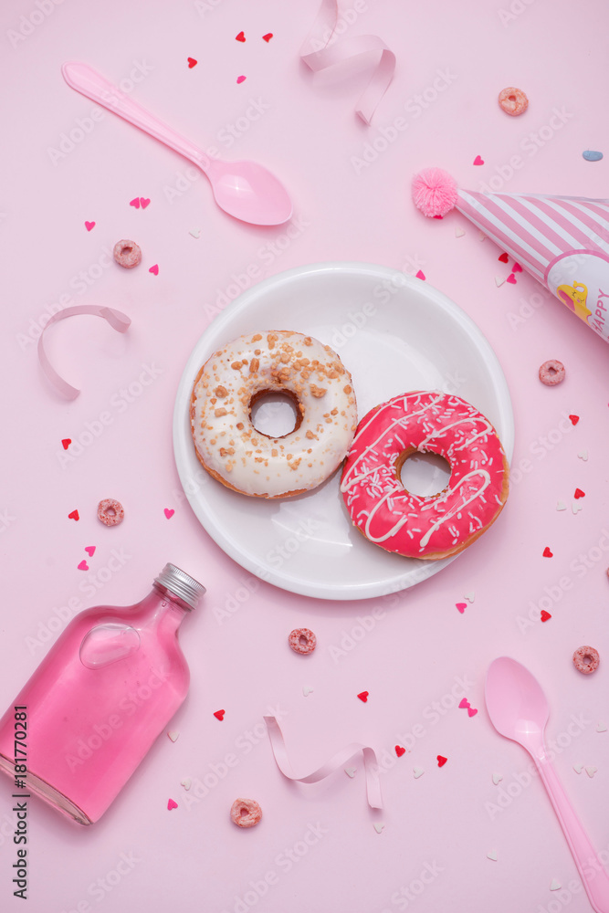 粉红色背景上五颜六色的圆形甜甜圈。平躺，俯视图。