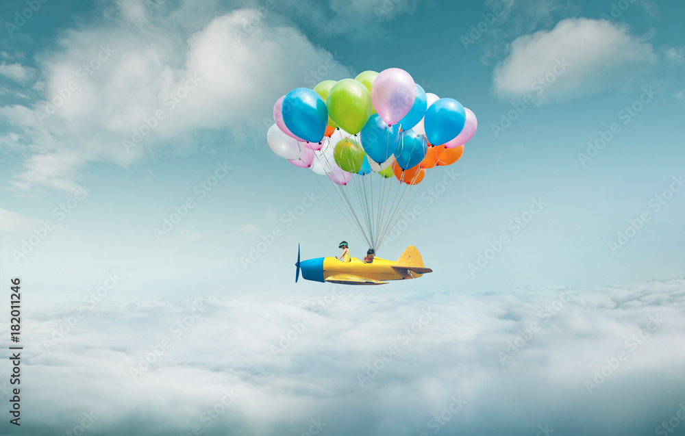 快乐的姐姐享受着梦幻般的飞机飞行，带着一堆五颜六色的气球漂浮在天空中。