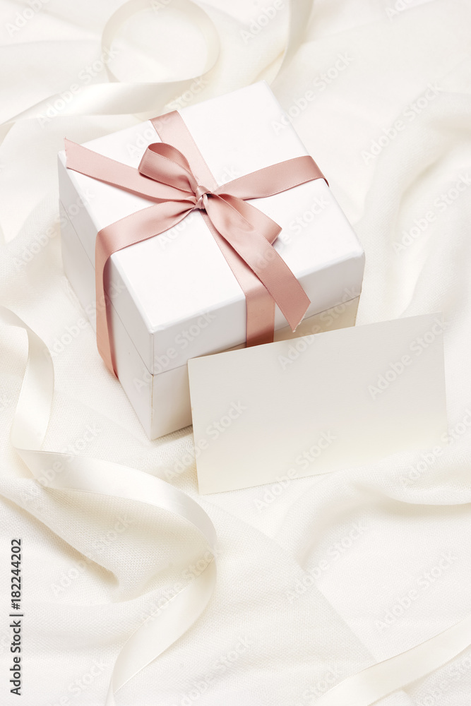 Romantic gift. Present on white silk background.