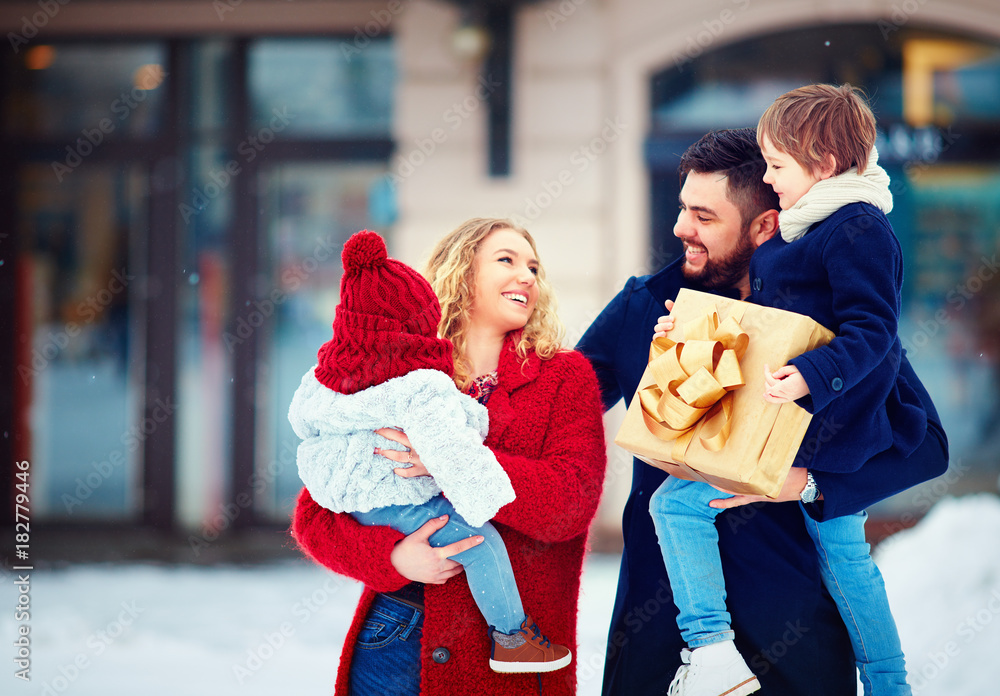 圣诞假期，白雪皑皑的冬季街道上幸福家庭的画像