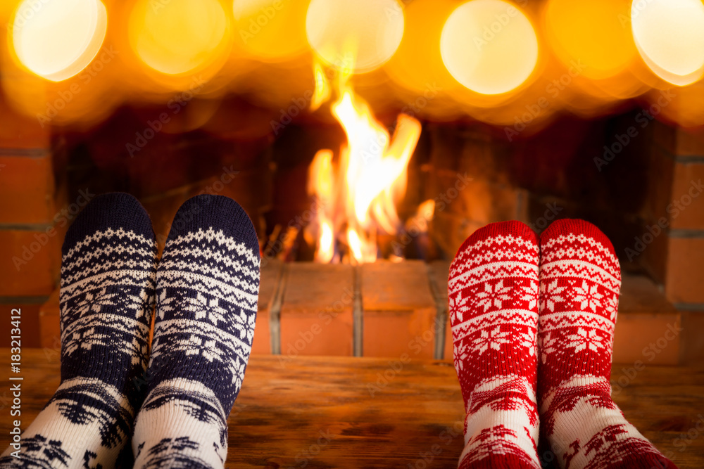 一对情侣穿着圣诞袜靠近壁炉