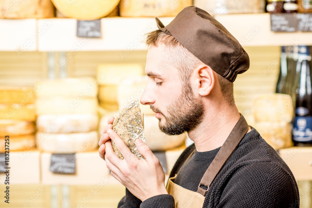 一位英俊的奶酪销售商的肖像，穿着制服，在商店前散发着调味奶酪的味道