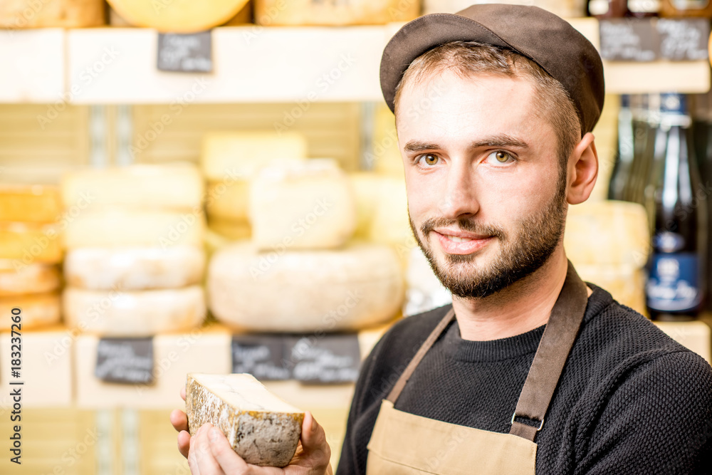 一个穿着制服的英俊奶酪销售商的肖像，在s面前拿着一杯调味奶酪