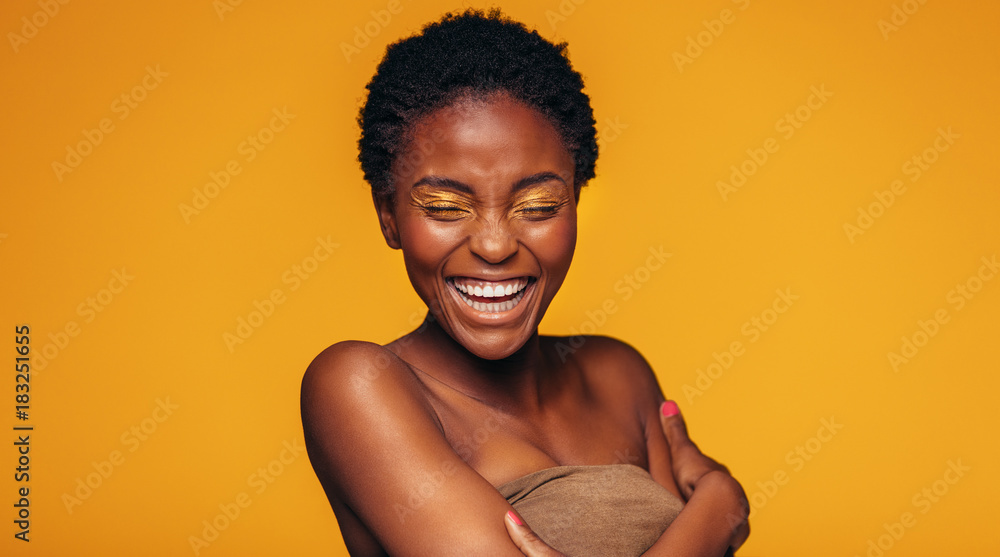 非洲女人在黄色背景下大笑