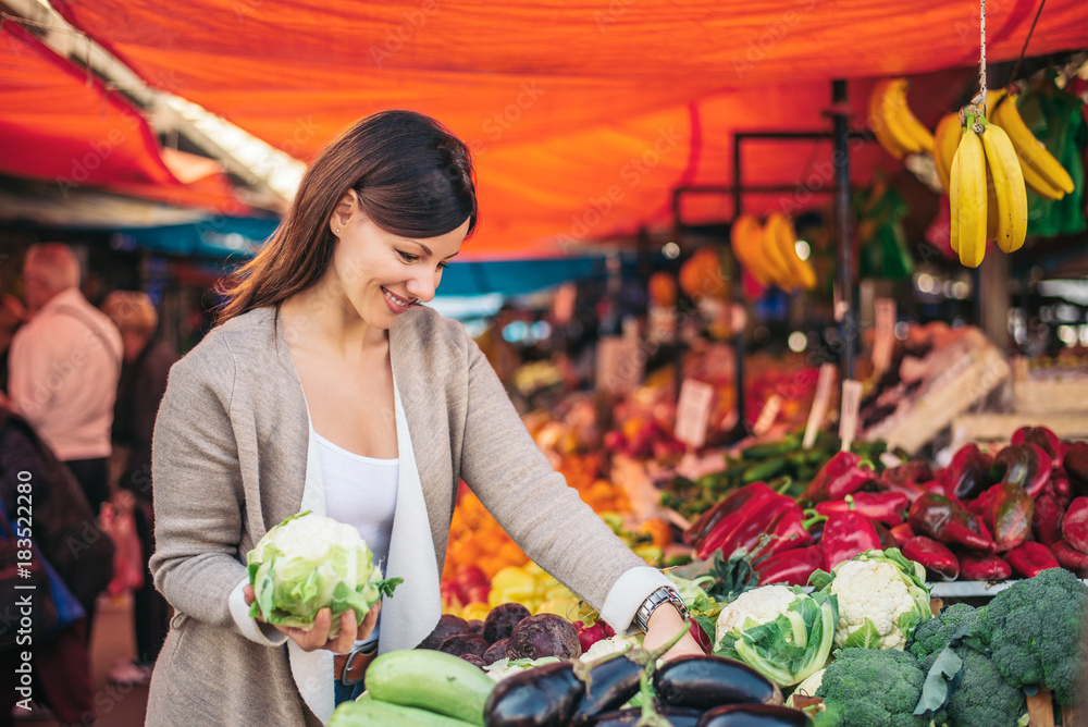 妇女在市场上挑选蔬菜。