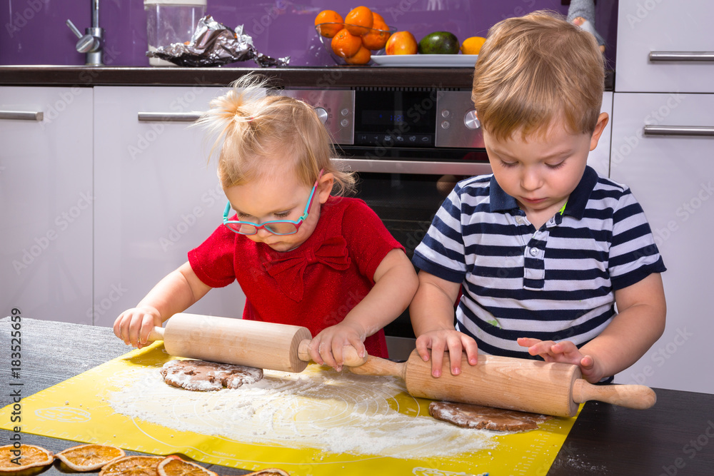 可爱的双胞胎小男孩和女孩在厨房准备圣诞饼干