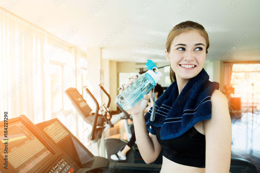 美丽聪明、健康的高加索年轻女子在健身房健身中心与blu一起锻炼时面带微笑