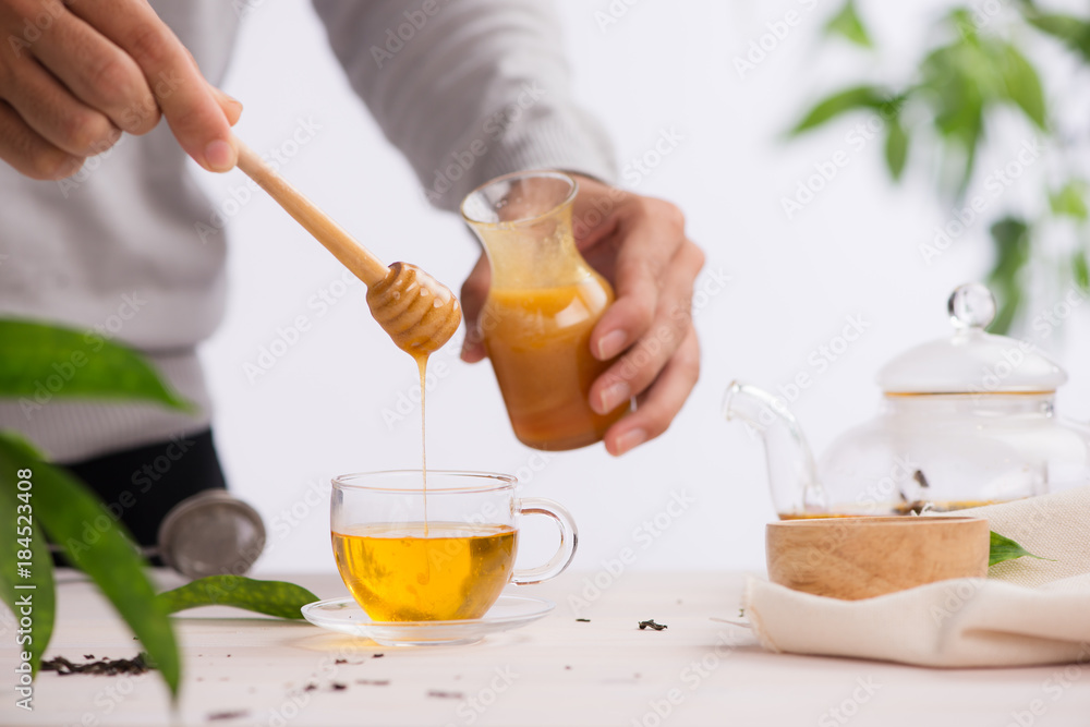 马兜铃将蜂蜜倒入茶中的裁剪图像