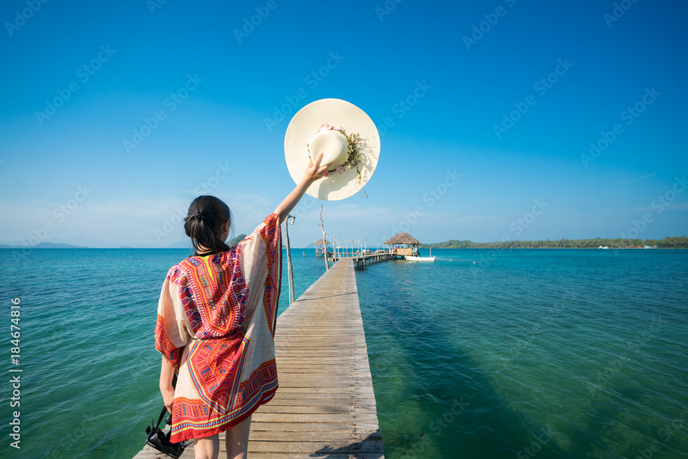 亚洲女士走在树木繁茂的桥上，前往Koh Mak、Mak和Kood岛的港口，这是泰国的旅游胜地