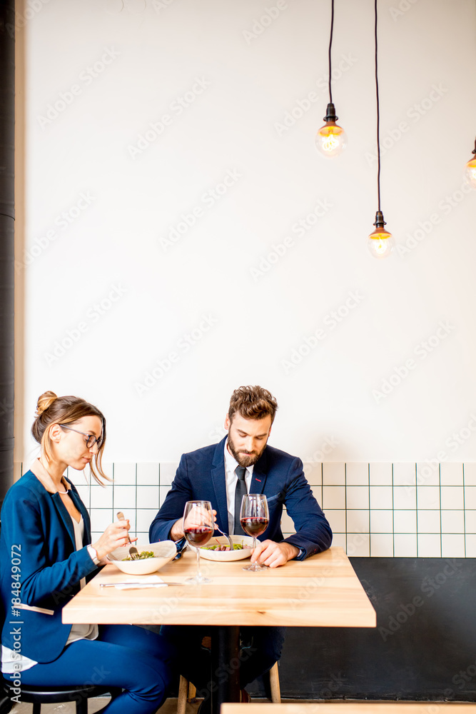 Business couple sitting together at the cafe during the dinner. Wide view with copy space on the wal