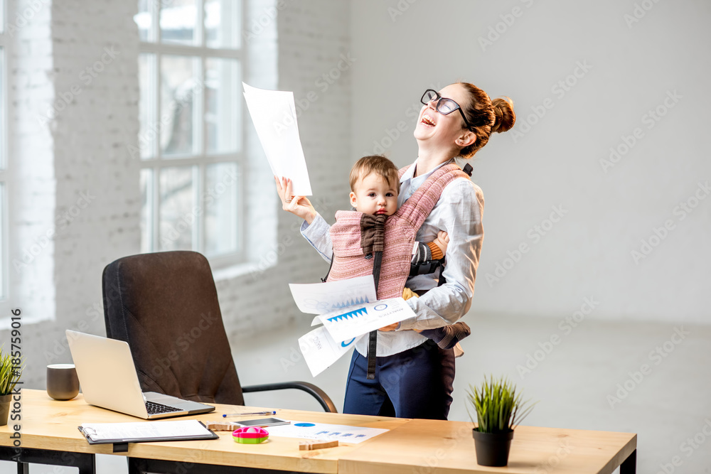 身兼数职的女商人拿着一堆纸质文件，她的小儿子站在办公室