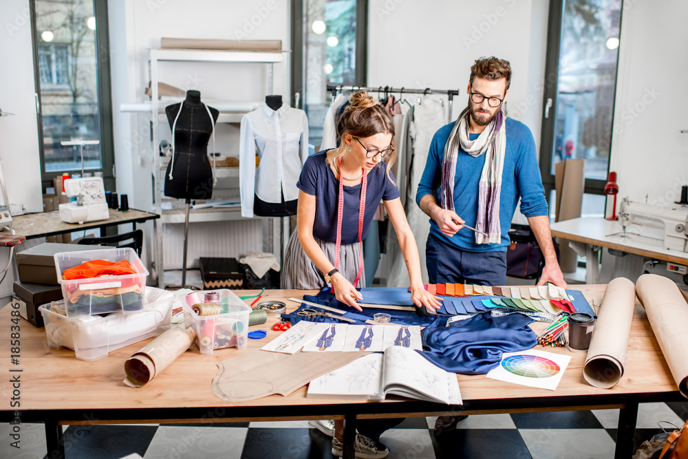几位时装设计师在充满泰洛林的工作室里创作面料和服装草图