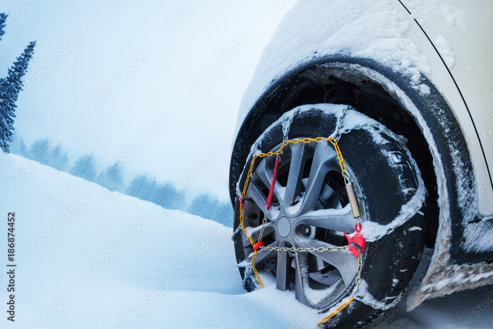 Wheel with snow tire chains on mountain road