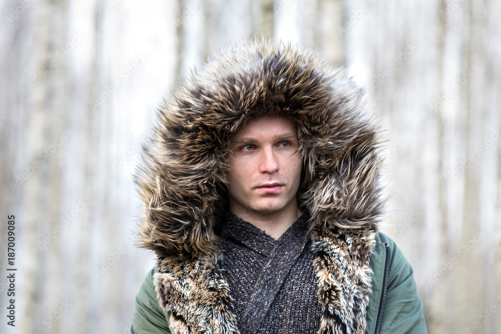 一个穿着蓬松冬季派克大衣的年轻人的肖像。