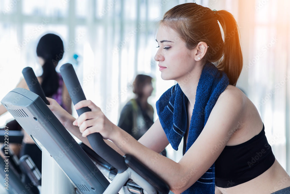 加拿大运动女性与一群人一起在健身房健身中心享受跑步机锻炼