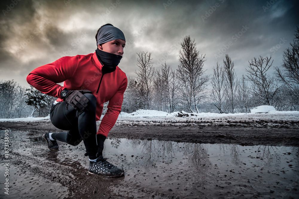 跑步者冬天在脏水坑里跑步，户外运动