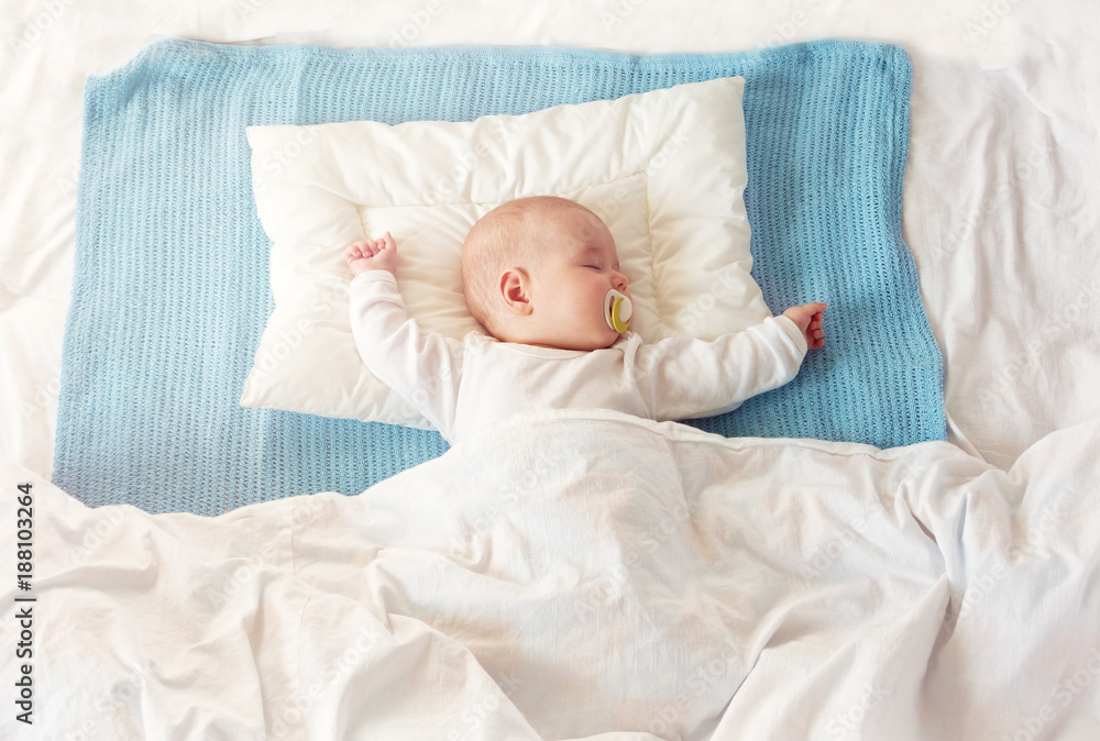 婴儿睡在蓝色毯子上