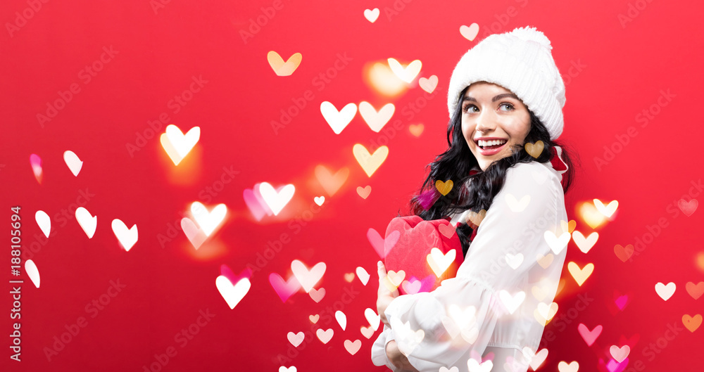 快乐的年轻女人拿着一个有爱心的大爱心礼盒