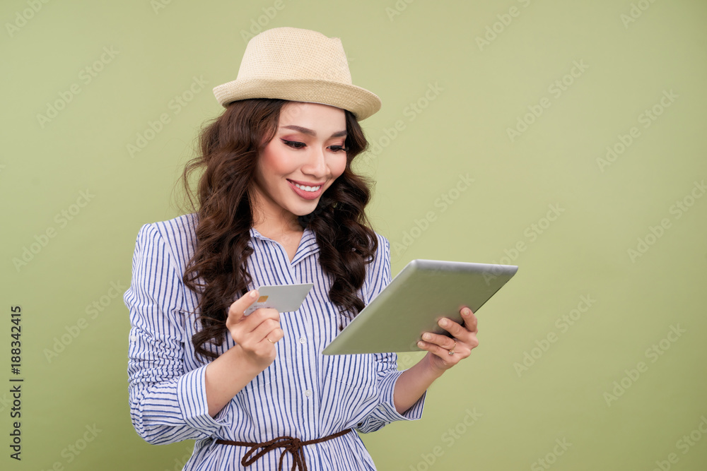 拥有信用卡和数字平板电脑的快乐微笑的女人。