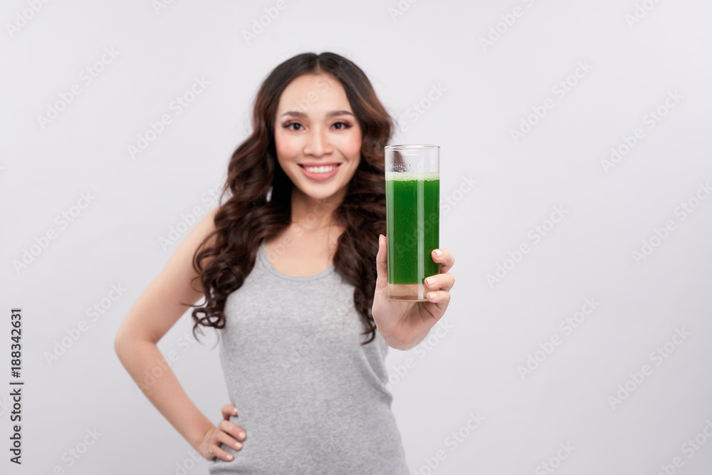 健康的亚洲女性拿着果汁杯。排毒奶昔饮料。