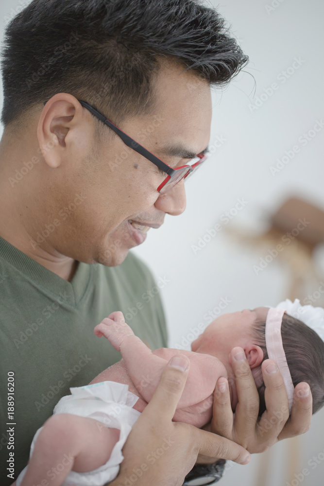 亚洲父亲小心照顾他可爱的新生儿