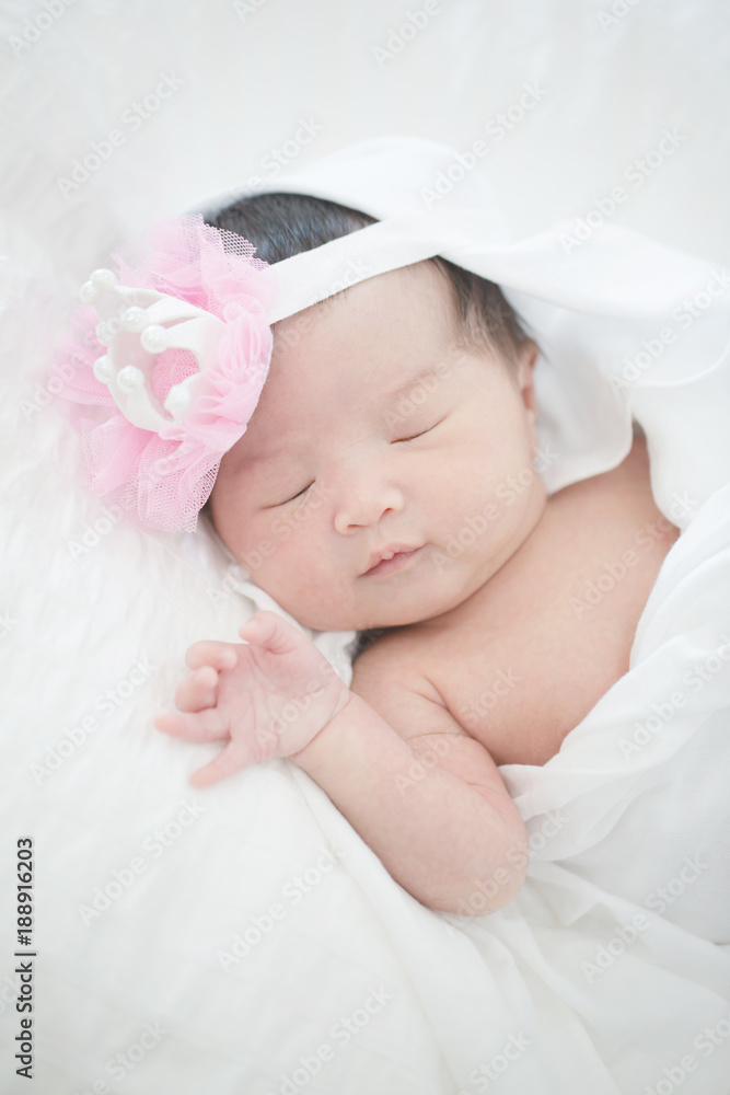 可爱的亚洲新生儿睡在毛茸茸的布上
