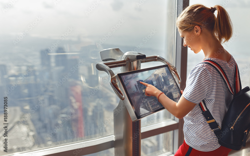 girl tourist with monitor of computer at window of skyscraper