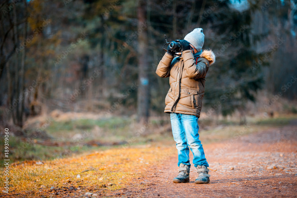 男孩使用数码相机在大自然中拍照，爱好概念