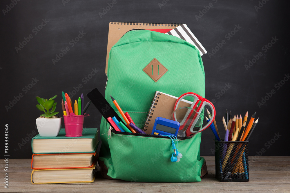 教育理念-学校书包，里面有书籍和其他用品，黑板背景