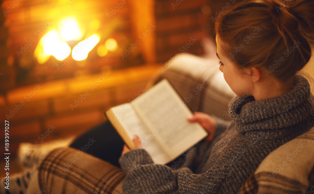 一个冬天的晚上，一个年轻的女人在壁炉旁看书。