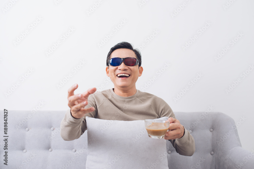 戴着3d眼镜的亚洲男子坐在沙发上看电影
