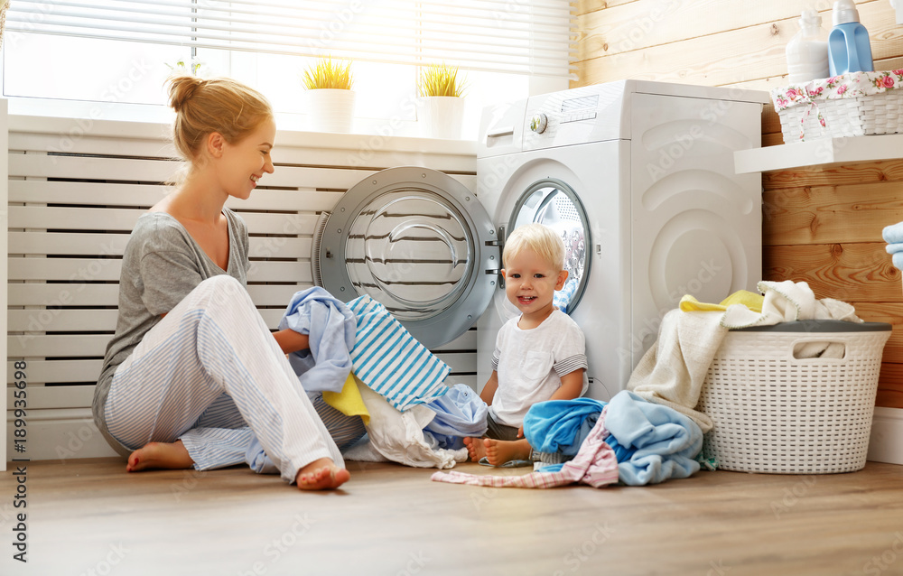 幸福家庭母亲家庭主妇和婴儿儿子在洗衣机里