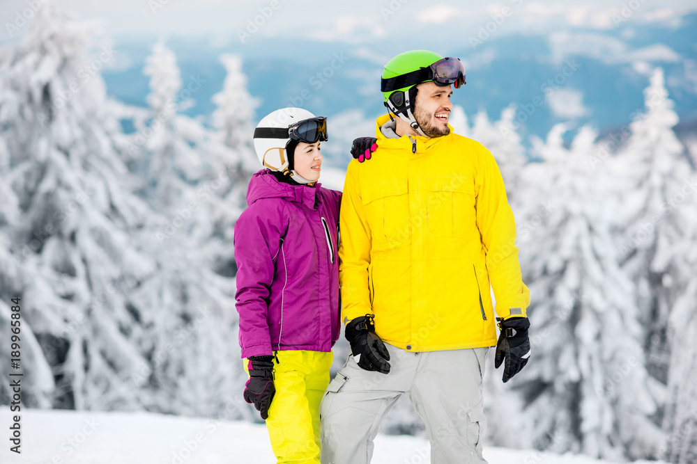 小情侣寒假穿冬季运动服站在雪山上