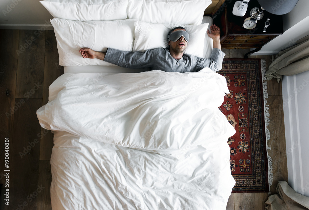 躺在床上睡觉的男人戴着眼罩