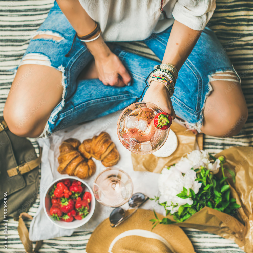 法式浪漫野餐场景。穿着牛仔裤的女人配一杯葡萄酒、草莓、羊角面包，b