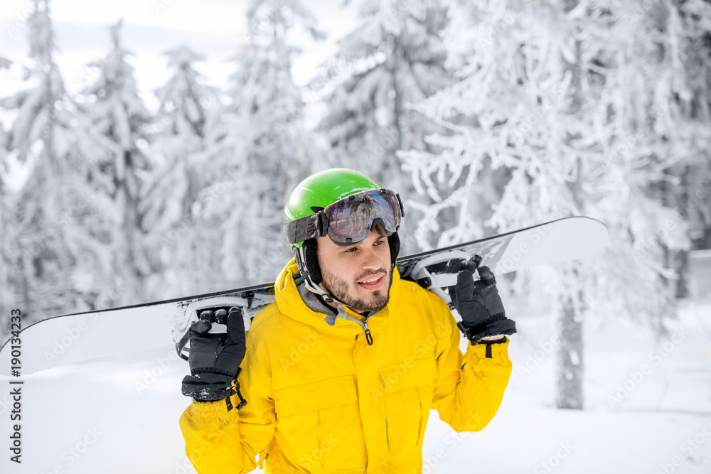身穿黄色冬季运动服的男子在雪山上滑雪板行走